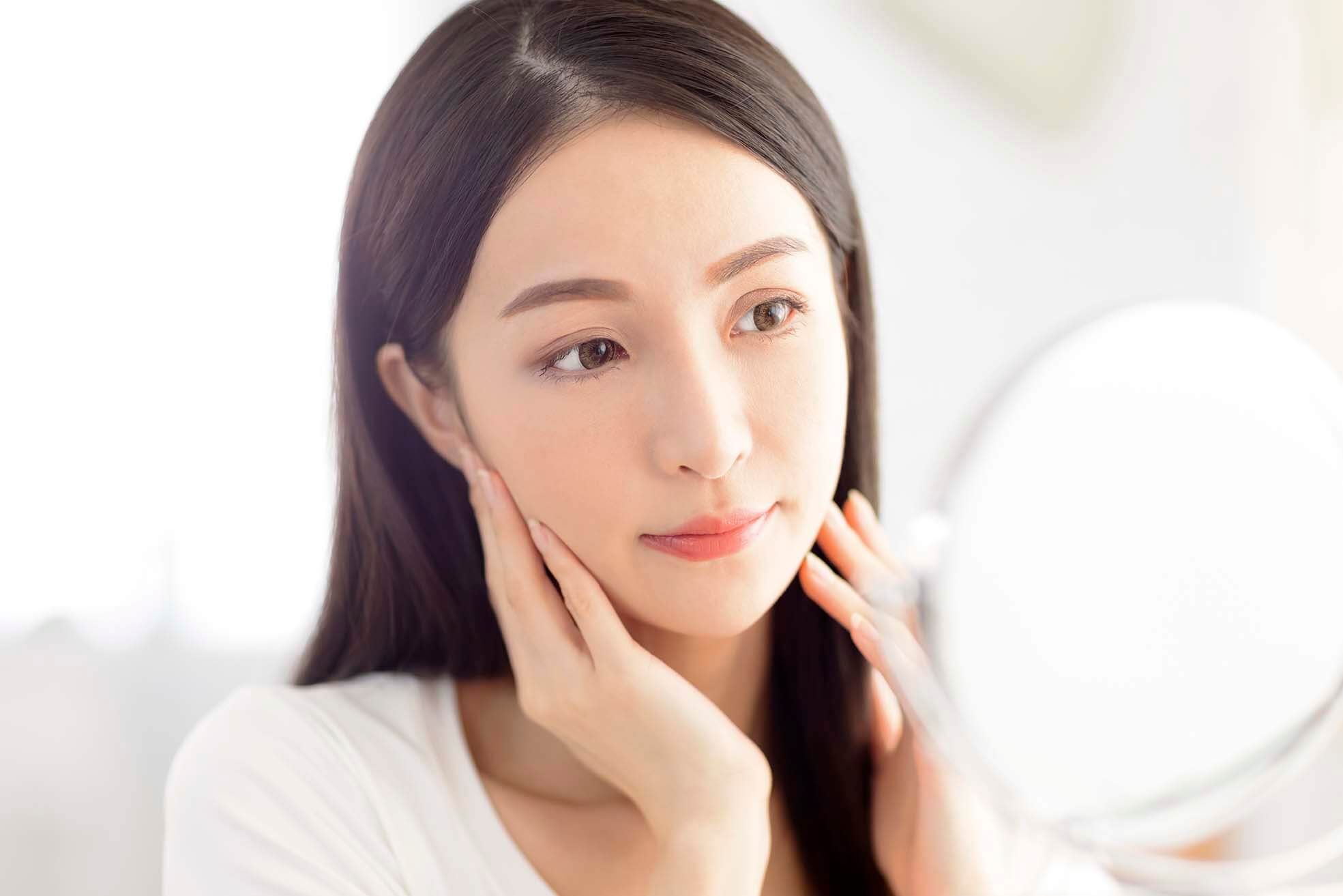 女生照鏡子查看是否出現肌膚衰老徵兆